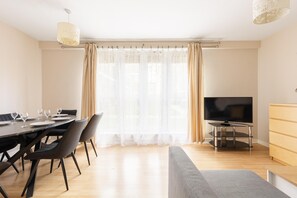 Ein modernes Wohnzimmer mit Essbereich, einem Flachbildfernseher und einer Holzkabine.
