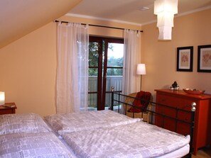 A bedroom with a bed, a chair, a dresser, and a window with curtains. - Holiday Home With 1 Bedroom (Rathmannsdorf)