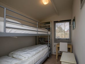A dormitory room with bunk beds, a desk, a chair, and a window with blinds. - Holiday Home With 2 Bedrooms (Burgh-Haamstede)