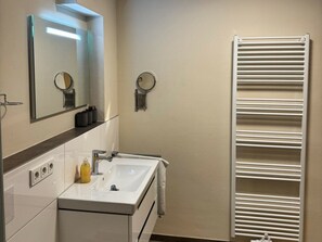 A bathroom with a white sink, mirror, and towel rack. - Holiday Apartment With 2 Bedrooms (Butjadingen)