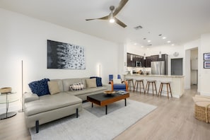 A modern living room with a sofa, coffee table, and a painting on the wall. - Remodeled modern north Scottsdale Town Home! (Scottsdale)