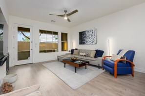 Una sala de estar moderna con un sofá, una mesa de centro y un sillón azul.