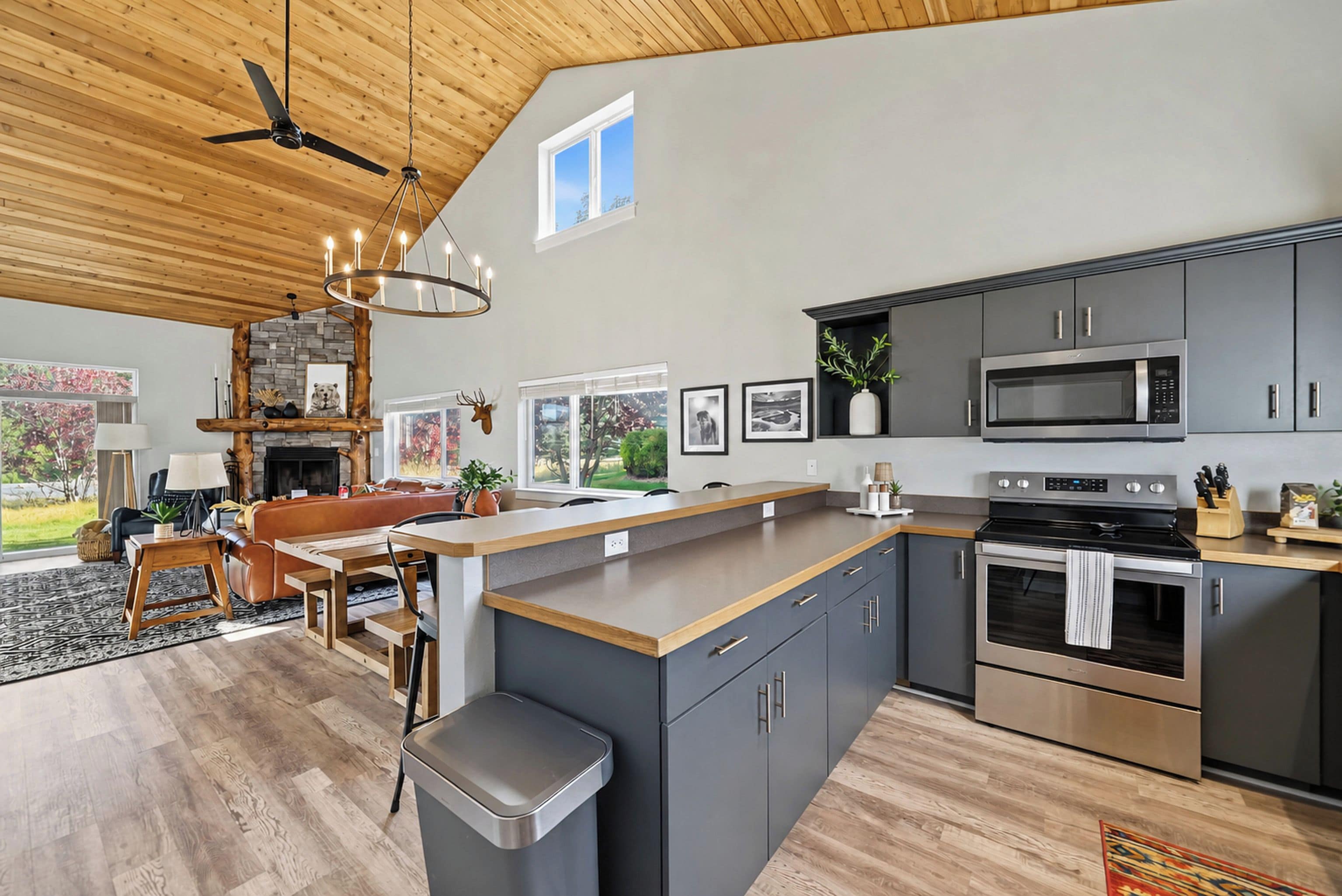 A modern kitchen with a central island, stainless steel appliances, and a dining area with a fireplace.