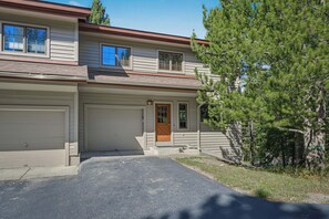 Een woonhuis met twee verdiepingen, een garage, een voordeur en een oprit.
