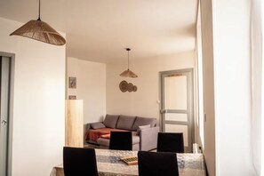 A dining area with a table, chairs, and a hanging light fixture. - Entire duplex apartment (Bourbourg)