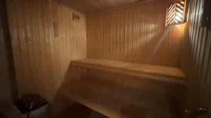 Una sauna con paredes de madera y un banco.