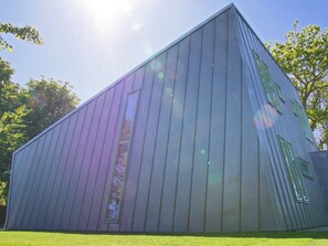 A modern building with a sloped roof and large windows. - Vakantievilla Sint Maartenszee (Sint Maartensvlotbrug)