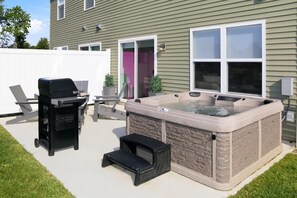 A backyard with a hot tub, a grill, and a patio area. - Hot Tub - Trail Access - Near Lake Michigan (South Haven)