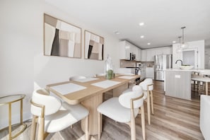 A modern kitchen with white cabinets, stainless steel appliances, and a central island. - Hot Tub - Trail Access - Near Lake Michigan (South Haven)