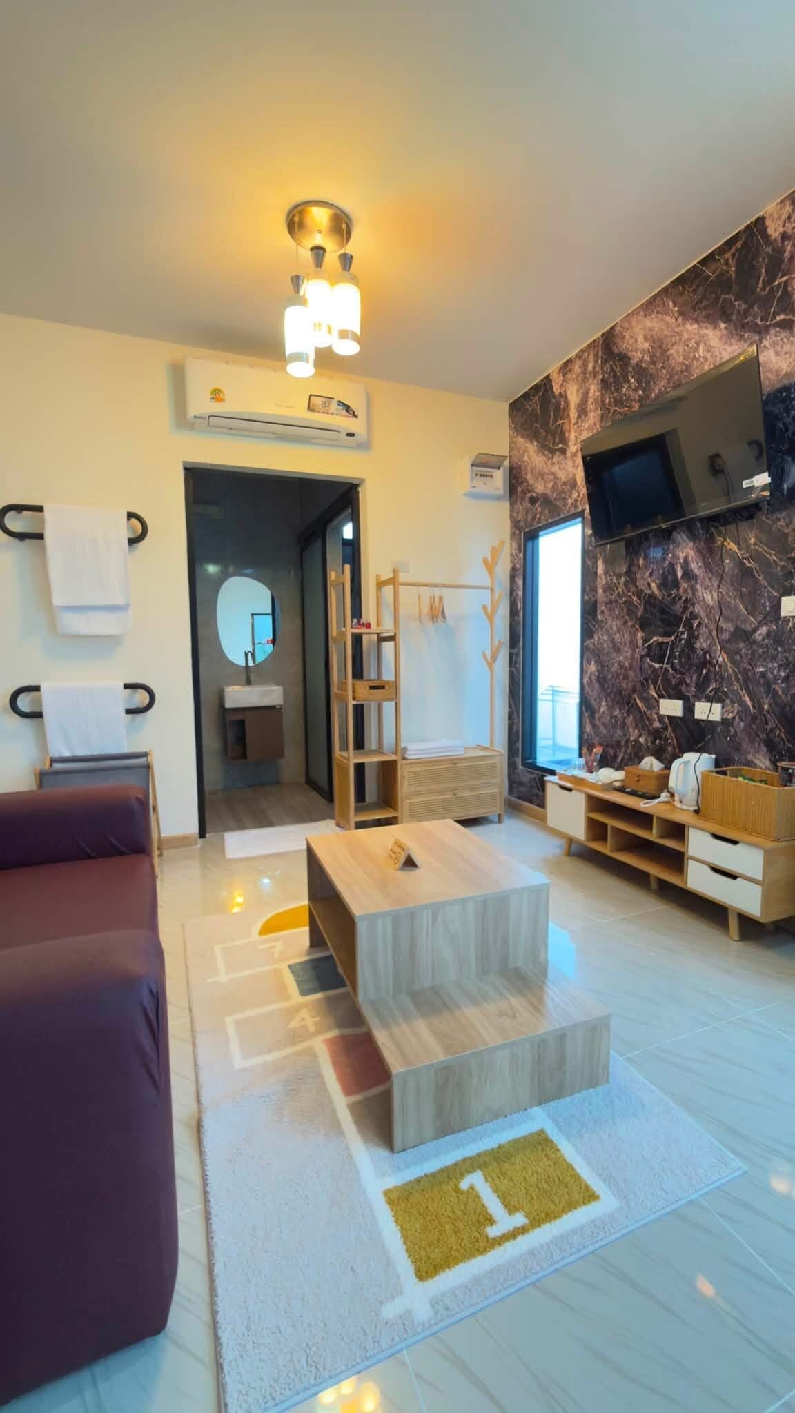 A modern living room with a sofa, a coffee table, and a TV mounted on the wall.
