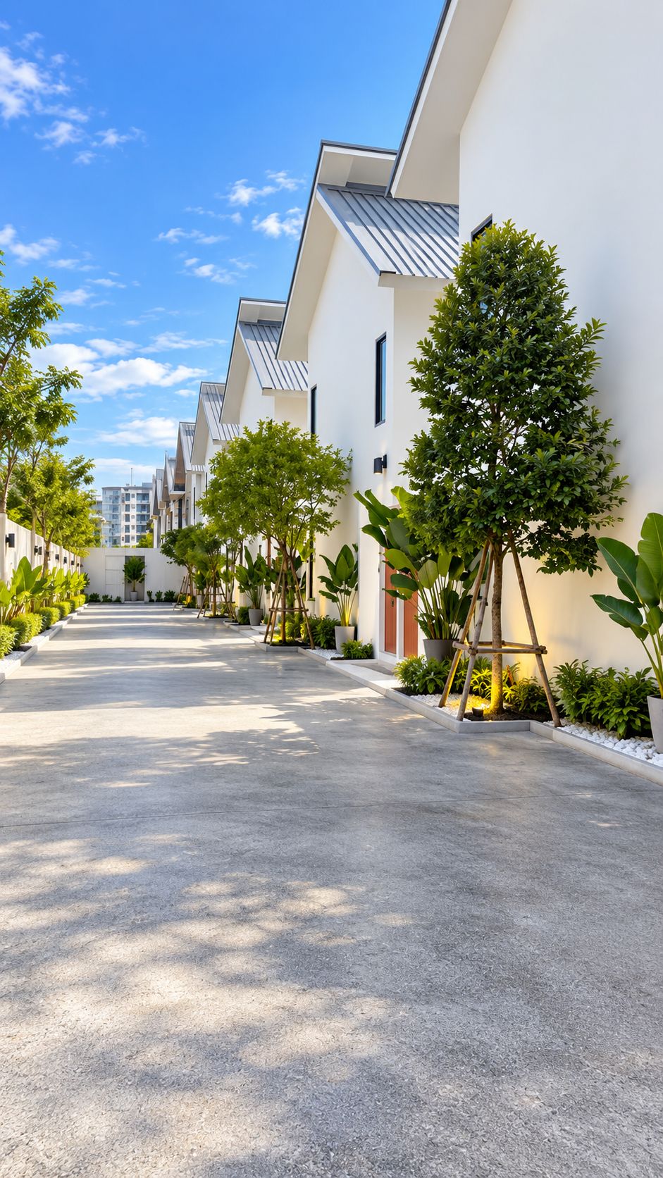Una hilera de edificios modernos con un sendero pavimentado y vegetación.