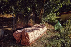 Un espacio al aire libre con un banco, una reja metálica y una botella verde.
