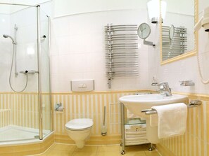 A modern bathroom with a glass-enclosed shower, a toilet, a sink with a mirror, and a towel rack. - Villa Fortuna BY THE Sea, Apartment 5 (Heringsdorf)
