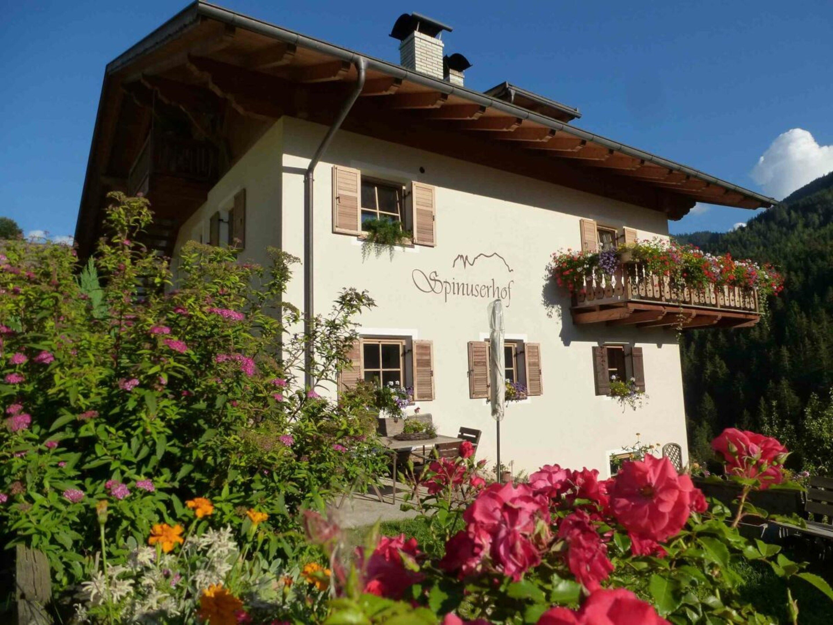 A building with a sign reading 'Spinuserhof' and a balcony with flower baskets.