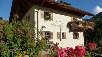 A building with a sign reading 'Spinuserhof' and a balcony with flower baskets.