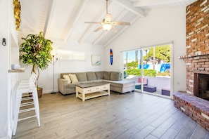 A spacious living room with a wooden floor, a grey sectional sofa, a coffee table, and a ceiling fan. - Short Walk To Sand Prefect For Families, Lrg Patio (Newport Beach)