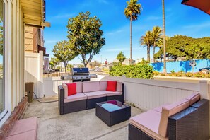 An outdoor patio with a sofa set, a grill, and a view of the street and palm trees. - Short Walk To Sand Prefect For Families, Lrg Patio (Newport Beach)