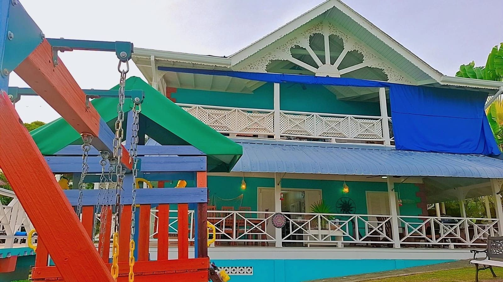 A two-story building with a balcony and a play structure in the foreground.