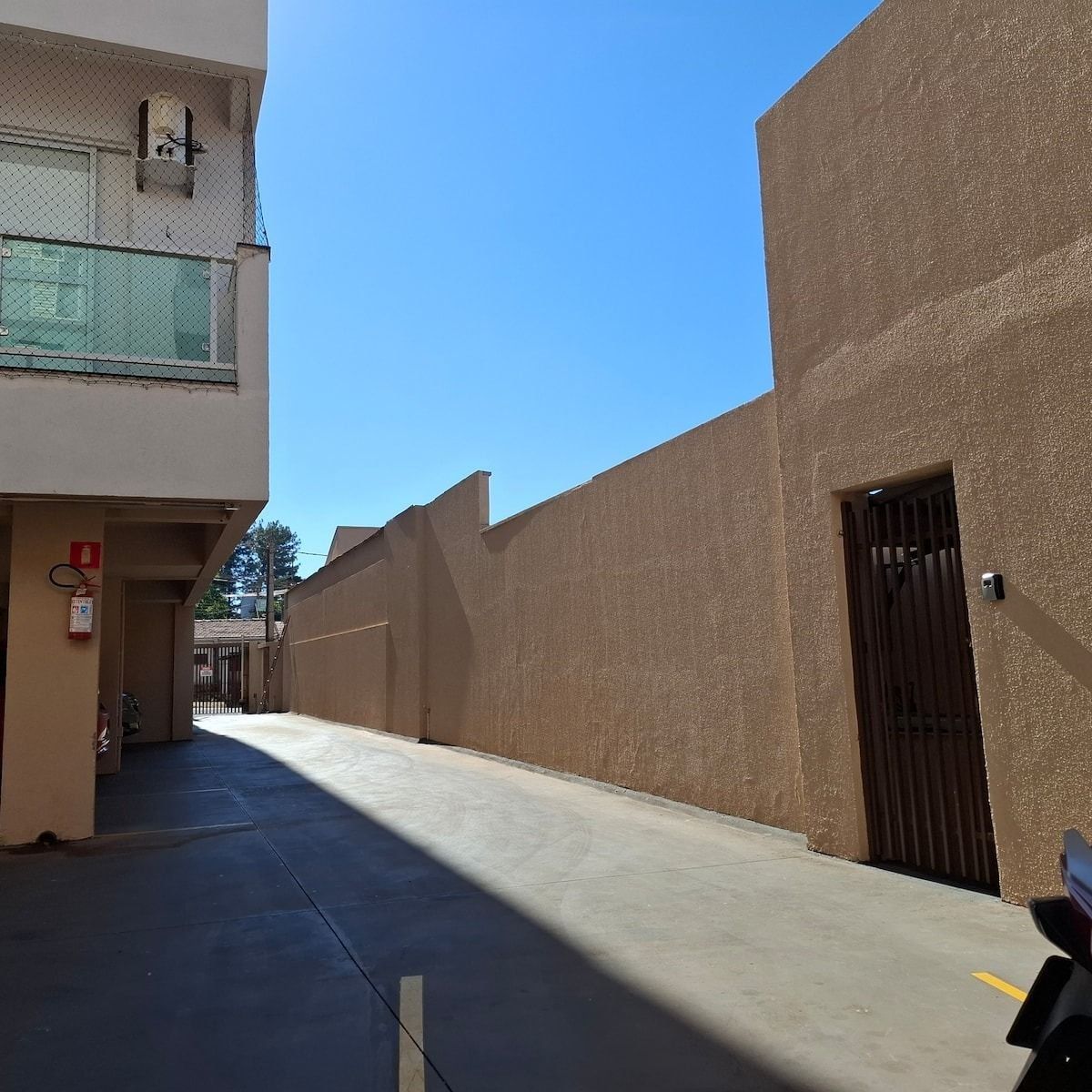 A narrow alleyway between buildings with a clear sky above.