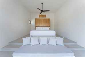 A bedroom with a bed, a ceiling fan, and a wooden headboard. - Modern home overlooking golf course with private pool - minutes to the beach (Tangolunda)