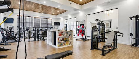 A gym with various exercise equipment, a bench, and a magazine rack.