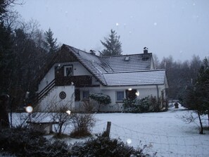 A house with a sloped roof, a visible chimney, and a snow-covered yard. - "studio" in the "white House Varwig" (Nebel)