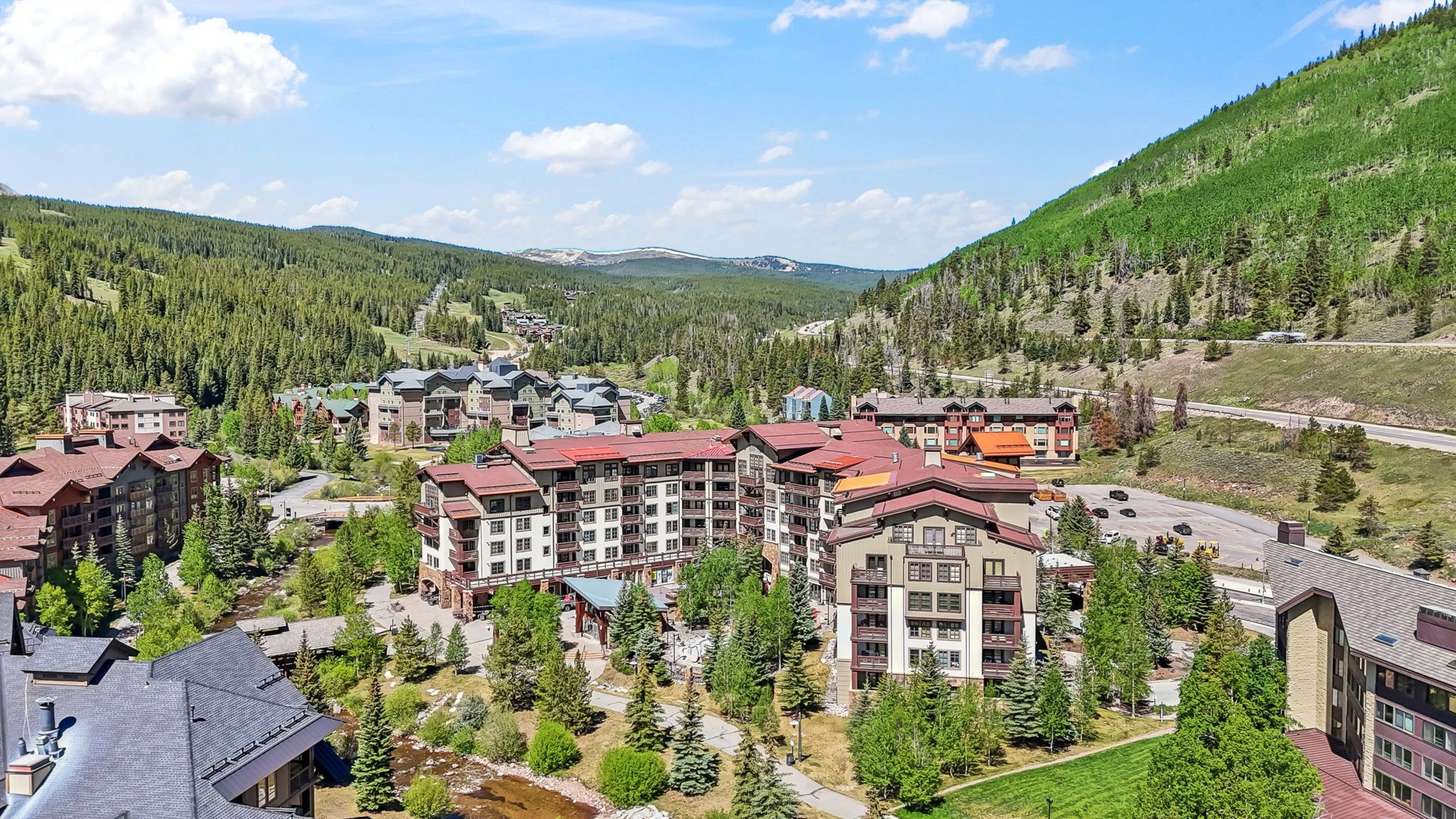 A resort with multiple buildings, a central courtyard, and a mountainous backdrop.