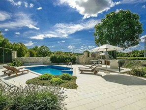 A swimming pool with lounge chairs, a barbecue area, and a pergola. - Villa in Sveti Lovrec With Swimming Pool (Sveti Lovrec)