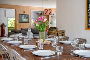 A dining table set with plates, glasses, and cutlery, a vase with flowers, and a number '22' on the wall. - Ker-eole - A côté du Port de la Trinité (La Trinite-sur-Mer)