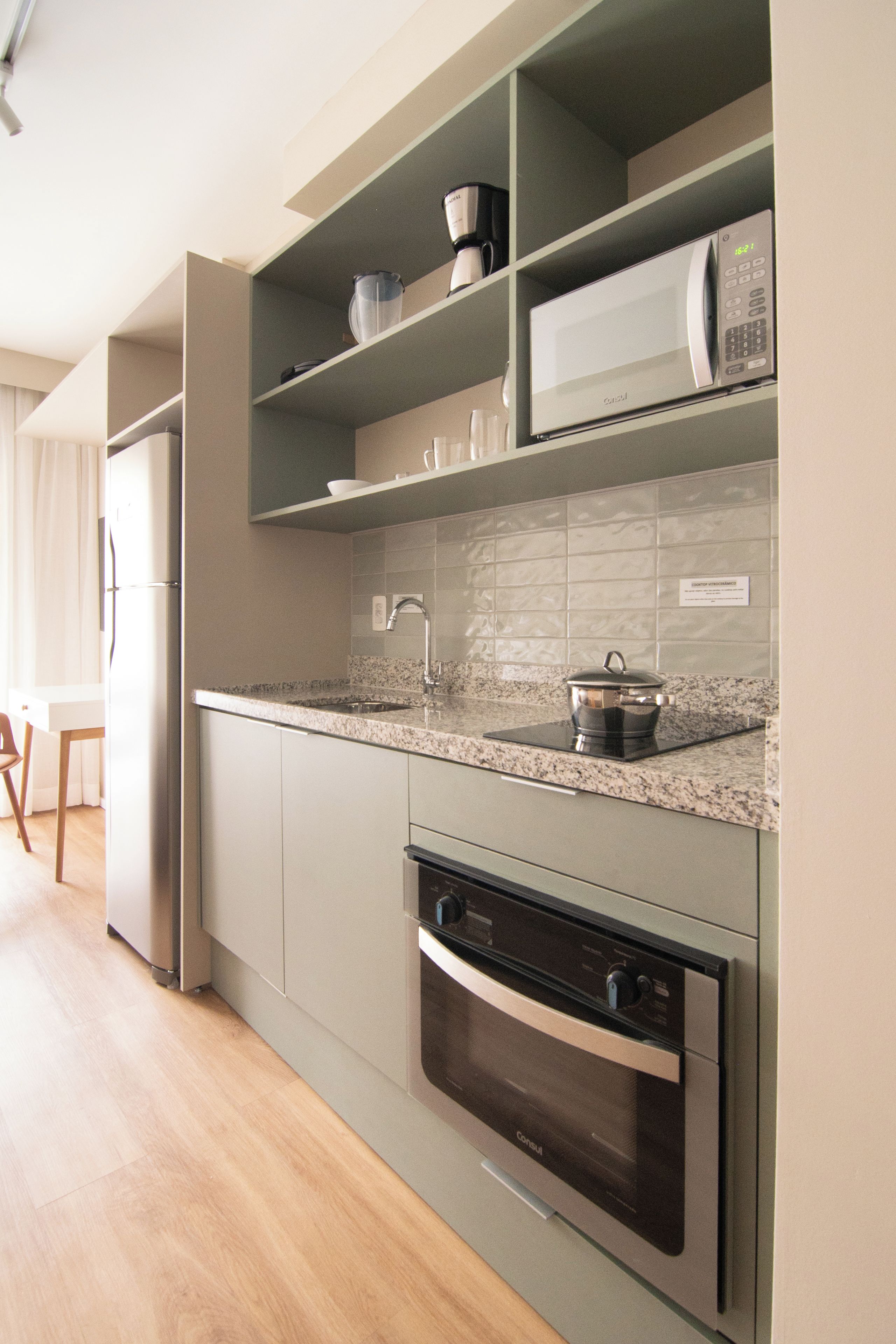 Eine moderne Küche mit integrierten Geräten, einer Arbeitsplatte aus Granit und einem Edelstahlbackofen.