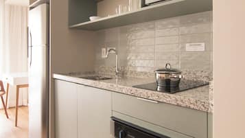 Eine moderne Küche mit integrierten Geräten, einer Arbeitsplatte aus Granit und einem Edelstahlbackofen.