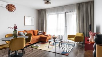 Un salon moderne comprenant un canapé, des fauteuils, une table basse et un coin repas.