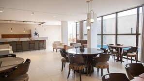 Eine moderne Hotelhalle mit einer zentralen Bar, Sitzbereichen und großen Fenstern mit Blick.