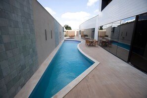 A modern building with a swimming pool, outdoor seating, and large windows. - Relaxing Room Perfect for Families and Leisure Travelers Visiting Araripina (Pernambuco)