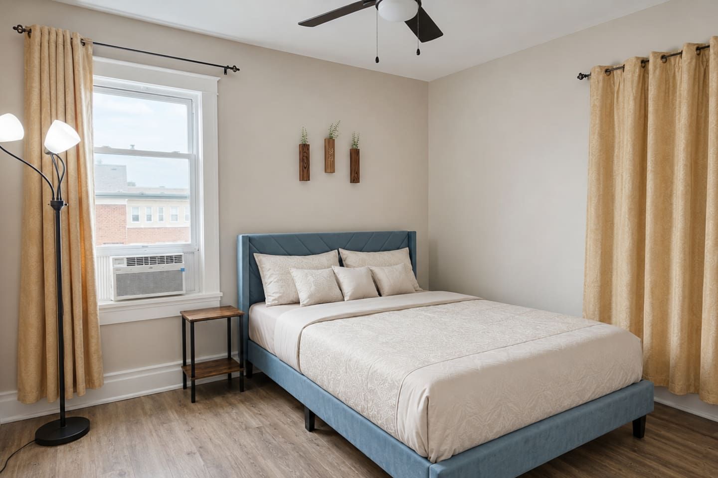 A bedroom with a bed, a window, a floor lamp, and a ceiling fan.