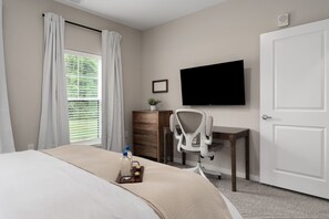 A hotel room with a bed, a desk, a chair, a television, and a window with curtains. - 1st Floor Luxury Furniture Pool Gym Golf (Westerville)