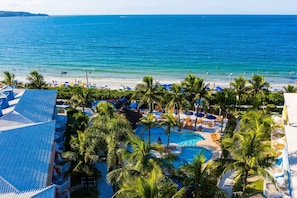 Un resort con piscina, playa y vista al océano.