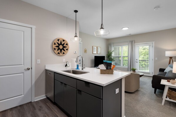 A modern kitchen with a central island, built-in appliances, and pendant lighting. - The Nook New Albany Area Balcony (Westerville)