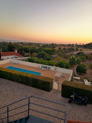A rooftop pool area with a view of the surrounding landscape.