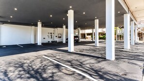 A covered parking area with white pillars and a clear sky. - Modern Renovated Condo - 90 Steps to Beach - Indoor Pool - OCMD (Ocean City)