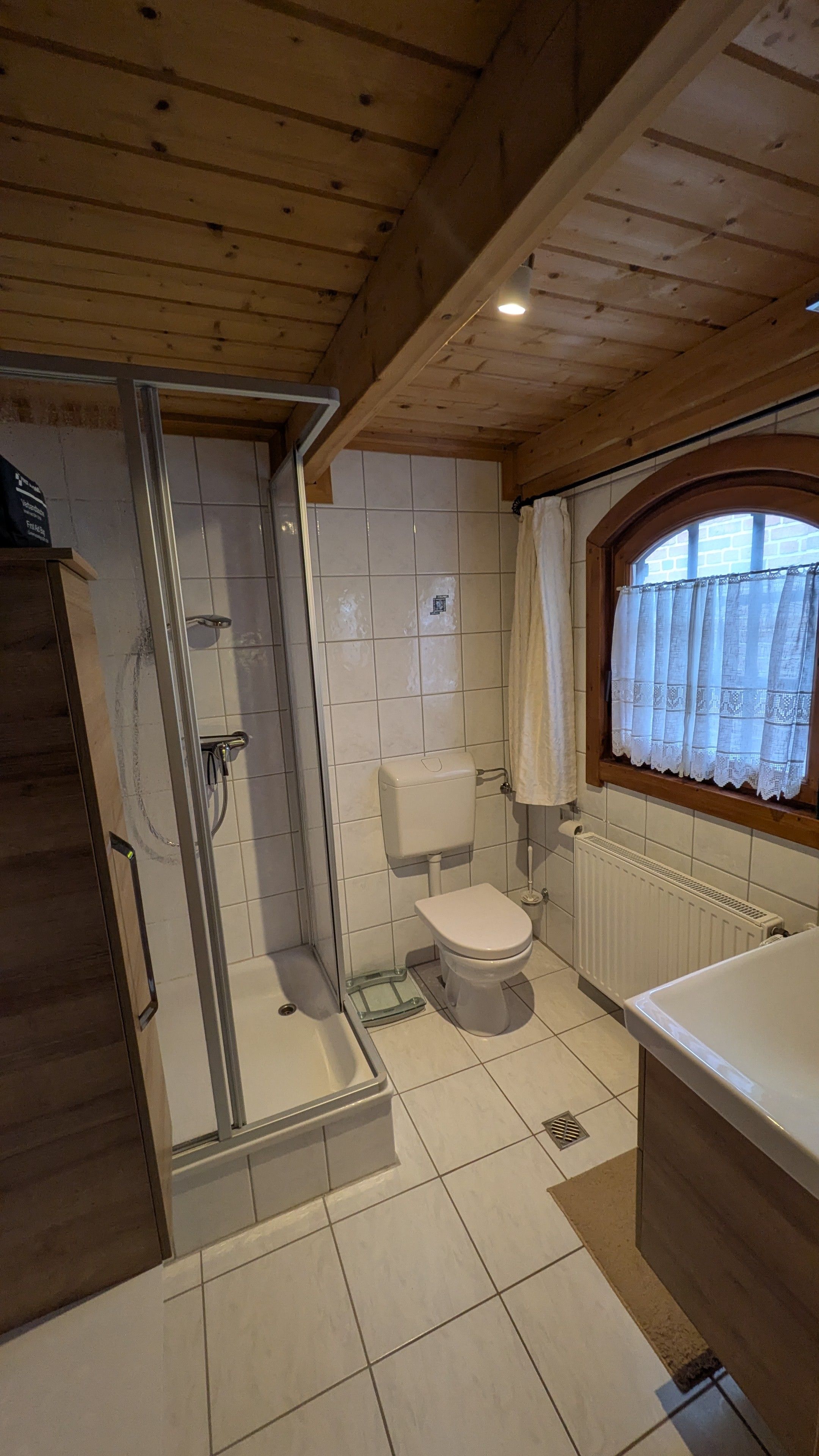 A bathroom with a shower, toilet, and sink.