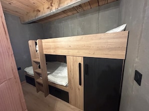 Ein Stockbett mit Holzgestell und Matratze.