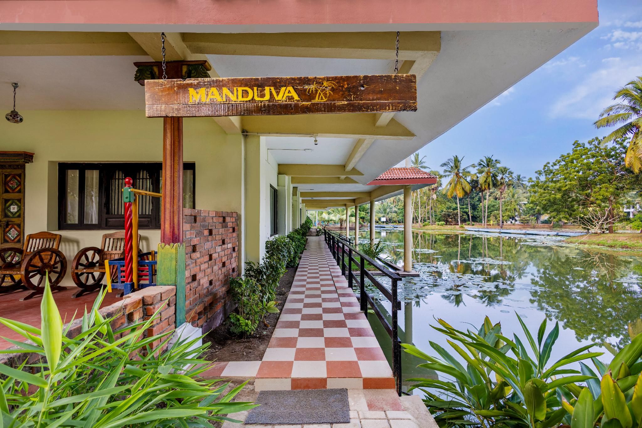 En rutig gångväg leder fram till en pool, och ovanför poolen finns en skylt med texten ”MANDUVA”.