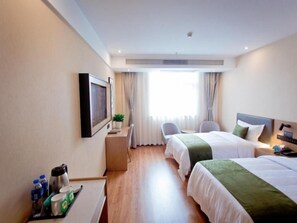A hotel room with two beds, a desk with a chair, a TV, and a window with curtains. - Greentree Hotel (Fuyang)