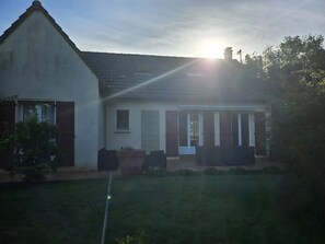 Een huis met een schuin dak, een veranda en een gazon.