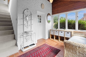 A staircase leading to a room with white brick walls, a large mirror, and a view of greenery outside. - The Barn A Cosy Countryside Retreat Near Eastbourne (Eastbourne)