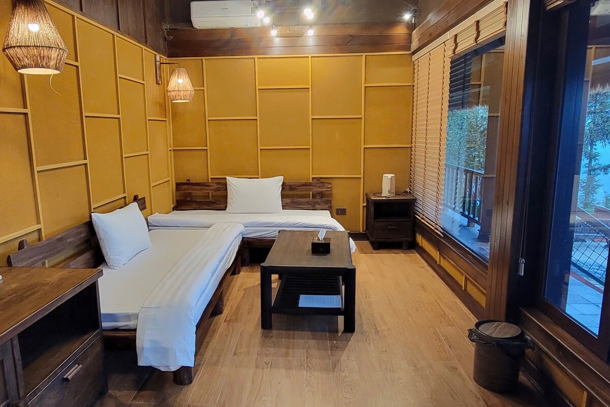 A room with a bed, a small table, and a window with blinds.