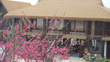 A traditional building with a thatched roof and a staircase leading to a balcony.
