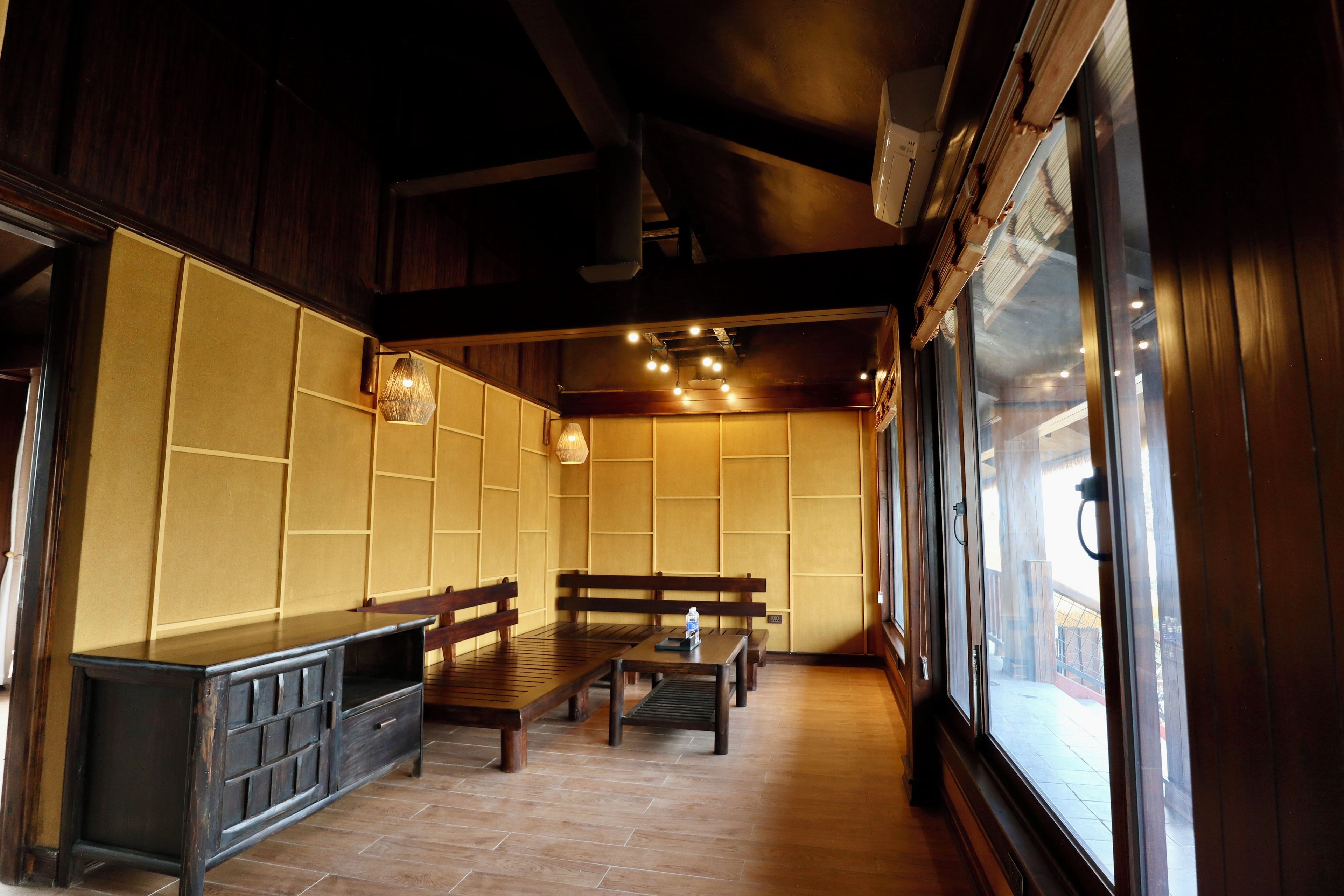 A traditional Japanese-style room with tatami flooring, low wooden tables, and benches.