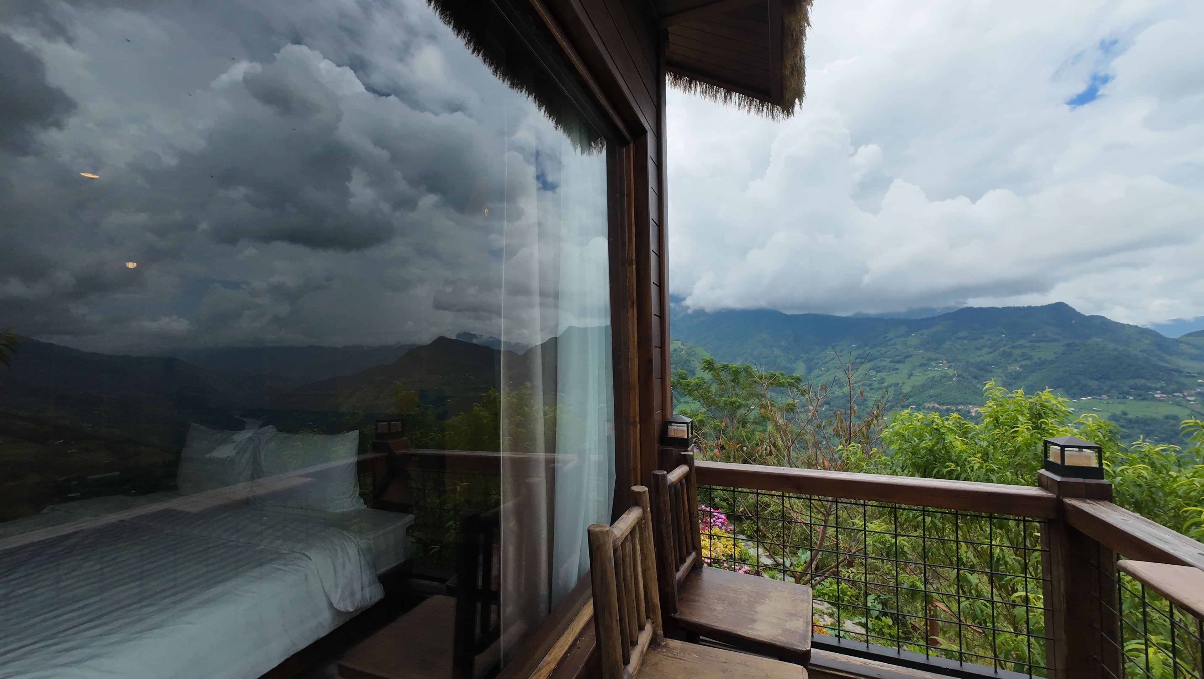 A room with a large window overlooking a mountainous landscape.